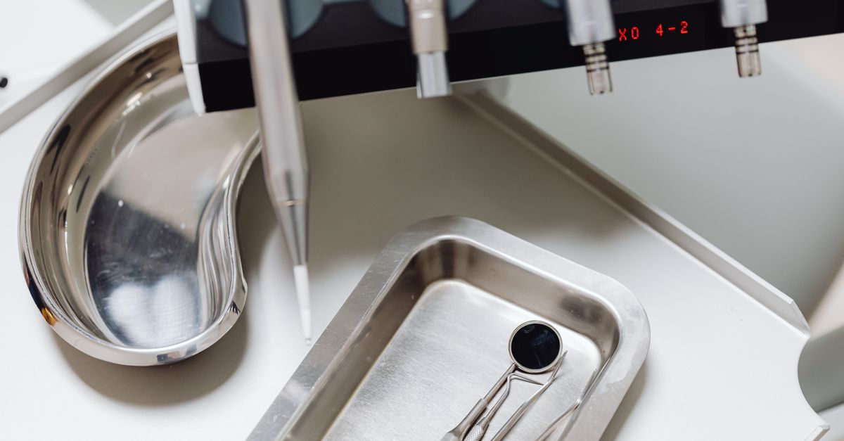 Dental instruments on a silver tray, ideal for illustrating medical and dental themes.